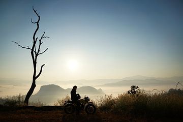 Motorrijder geniet van de zonsopgang in Thailand van Floris Verweij