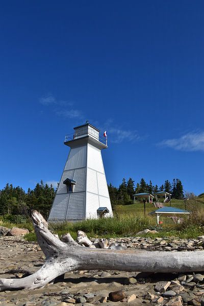 A small lighthouse under a blue sky by Claude Laprise