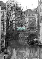 Zwartwit foto van de Oudegracht in Utrecht met groene bus
