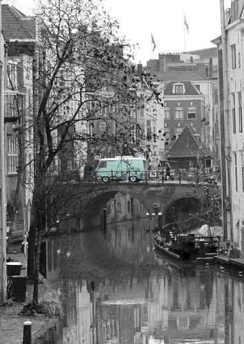 Photo en noir et blanc de l'Oudegracht à Utrecht avec un bus vert