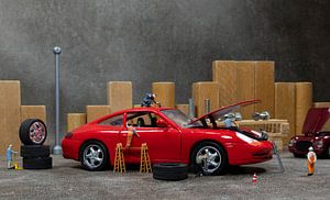 Little World Miniaturen arbeiten in einer Autowerkstatt, reparieren ein Auto, wechseln Reifen und üb