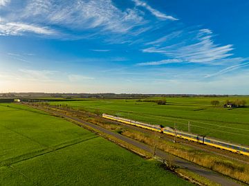 Zug der Niederländischen Eisenbahnen NS bei der Fahrt durch die Landschaft von Sjoerd van der Wal