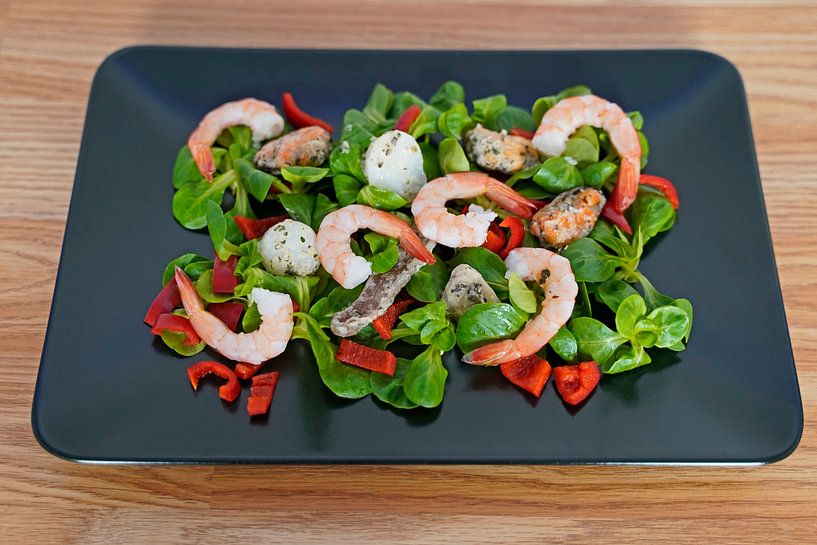 Lamb's lettuce with peppers and seafood served on a black serving platter by Babetts Bildergalerie