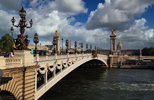 Golden statues on the Pont Alexandre III bridge and the dome of Les Invalides in Paris, France