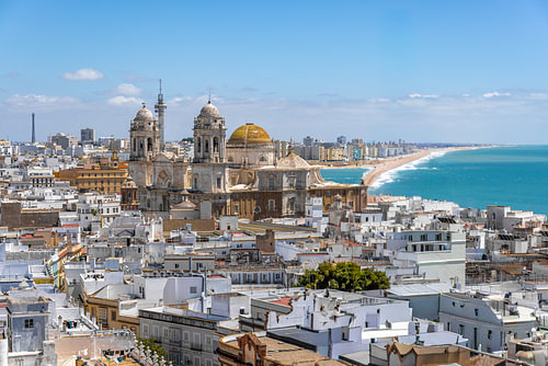 Kathedrale von Cádiz über weißen Dächern und dem Strand