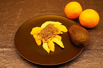 Salade van avocado en sinaasappel met koolvis op een bord