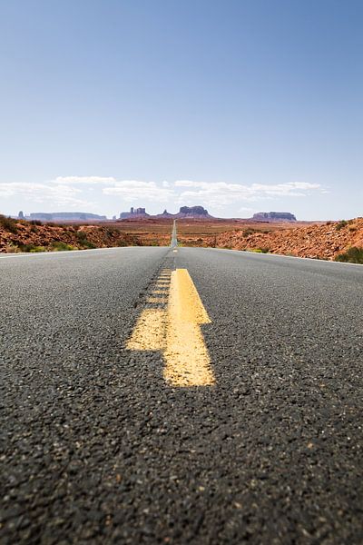Yellow stripe on asphalt road leading to Monument Valley by Moniek Kuipers