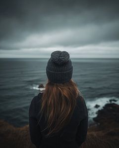 Junge Frau schaut über die Küstenlandschaft