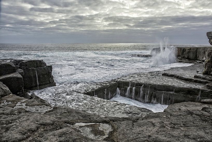 Zee kliffen gat in de rots genaamd The Wormhole op Aran Islands, Ierland van Tjeerd Kruse