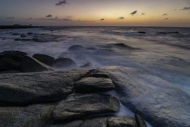 Waves crashing over the rocky coast at the north coast of Aruba during sunset by Arthur Puls Photography