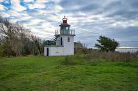 Lighthouse by the sea and rays of sunshine by Martin Köbsch