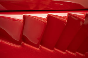 Detailansicht eines roten Oldtimers. Luftansaugstutzen in Ferrari-Rot.