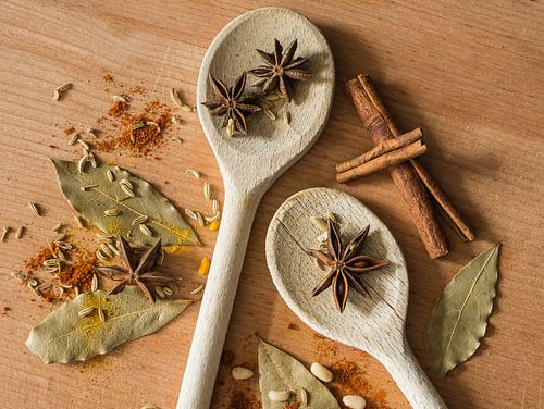 Spices on wooden spoons on shelf