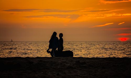 strandwandeling met een in de zee verdwijnende zon