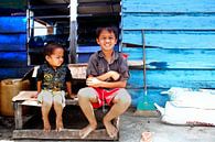 Indonesische kinderen met op de achtergrond een blauw huis von André van Bel Miniaturansicht