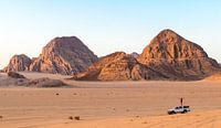 A man standing on a jeep in the Wadi Rum desert in Jordan