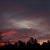 Donkere wolkenlucht in donkerblauw, grijs, roze, rood en oranje | Landschapsfotografie van Monique Tekstra-van Lochem