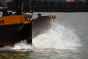 Voorsteven van varend schip met opspattend water