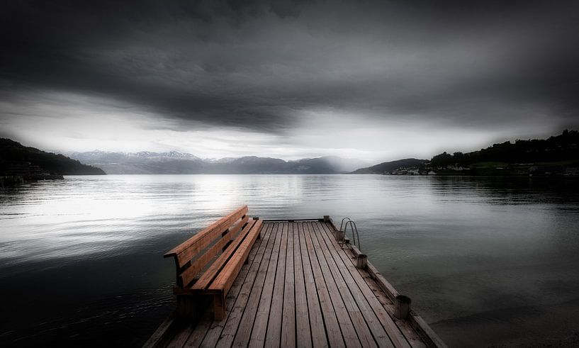 Eine mystische Landschaft an einem norwegischen Fjord an einem dunklen Tag von Bas Meelker