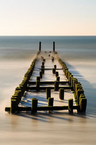 Golfbreker aan het strand in het water.