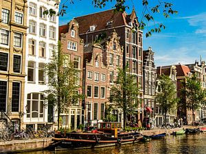 Huisgevels en straatboten op een gracht in Amsterdam Nederland van Dieter Walther