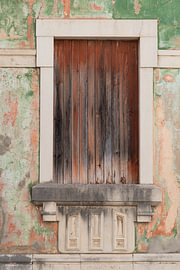 A weathered wooden door in pastel shades in Loulé, Portugal