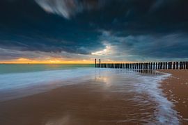 Dutch clouds and typical breakwater of wooden poles along the coast of Zeeland by gaps photography