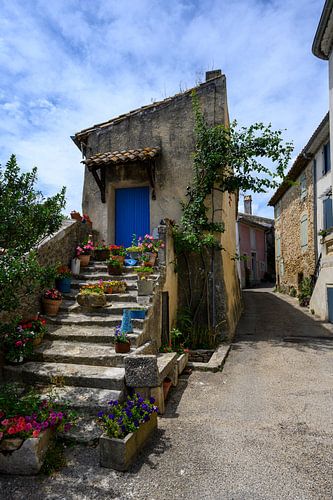 Maison avec un long escalier en pierre rempli de fleurs