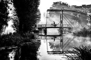 Ein einsamer Zeitungszusteller radelt über eine Brücke in IJlst Friesland. One2expose Wout Kok Fotog