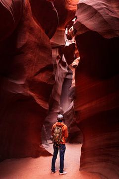 Man stands among the undulating rock drawings in Lower Antelope Canyon by Moniek Kuipers