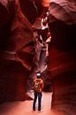 Man stands among the undulating rock drawings in Lower Antelope Canyon by Moniek Kuipers thumbnail
