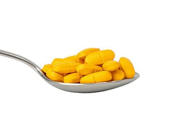 Grote lepel met veel gele pillen