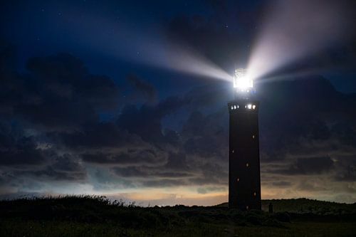 Vuurtoren van Ouddorp in de duinen met lichtbundels bij nacht