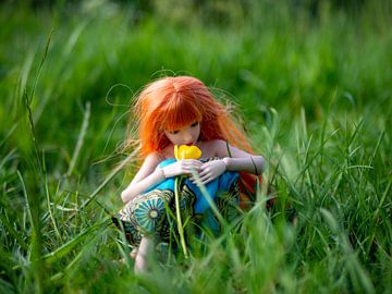 Red haired girl sitting in the grass