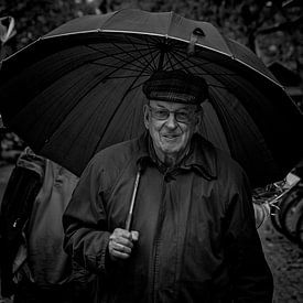 Man with umbrella at market by Ton Van Zeijl