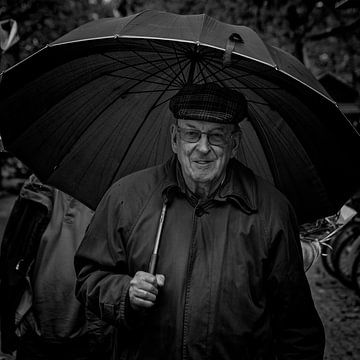 Man met paraplu op de markt van Ton Van Zeijl