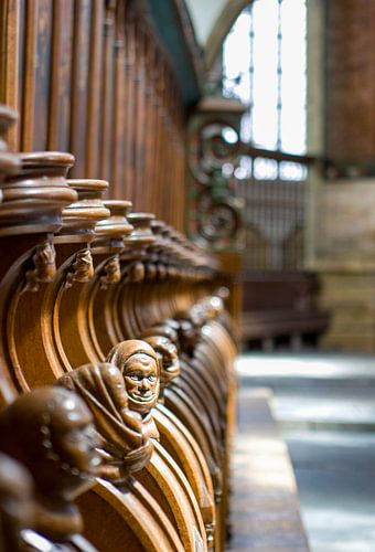 Koorbanken met houten, gebeeldhouwde hoofden in de Sint-Bavokerk