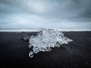 IJsberg op het donkere zandstrand van Diamond Beach, IJsland van Teun Janssen