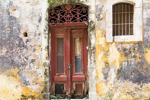 Roodbruine oude deur en raam in gevel.