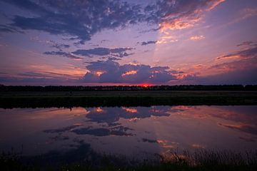 Zonneharp bij ondergaande zon spiegelt in water van Theo Felten