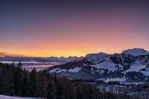 Sicht auf die bekannten verschneiten Berge Schreckhorn, Eiger und Thunersee im Winter bei Sonnenaufgang