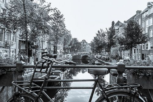 Old bicycle on a canal in Amsterdam - monochrome