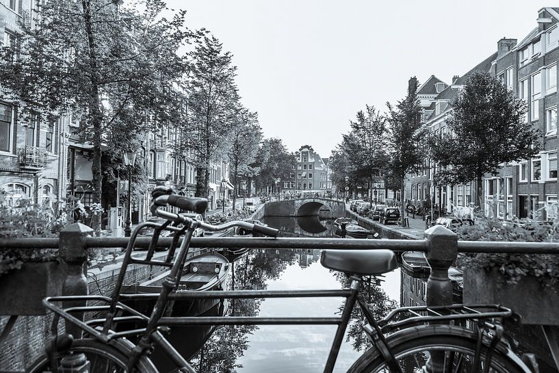 Old bicycle on a canal in Amsterdam - monochrome by Werner Dieterich