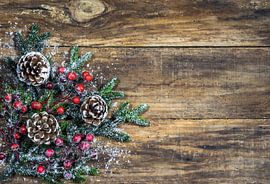 Natuurlijke kerstachtergrond met dennenappels, rode bessen en groene sparrentakken van Alex Winter