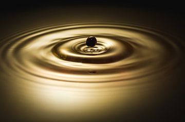 zwarte druppel valt in goud water van Jolanda Aalbers