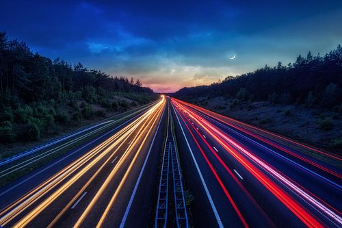 A1 SNELWEG MET VERKEER EN MAAN IN HET BLAUWE UUR.