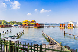 Rondvaartboten in traditionele Chinese stijl aan de aanlegsteiger in Hangzhou van Marc Venema