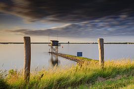 schöner Sonnenuntergang hinter einem Fischerhaus am Wasser in Scharendijke in der Provinz Zeeland von gaps photography