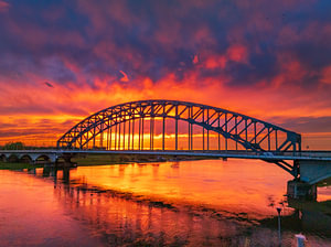 Brücke in einem farbenprächtigen Sonnenuntergang über dem Fluss IJssel