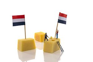 miniatuur poppetjes zetten vlag op de kaas